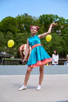 Young dancer performing outdoors in bright turquoise dress Stock Photos