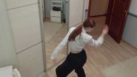 Young dancer practicing modern choreography in front of mirror Stock Footage 310533778