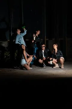 Young dancers performing a coordinated routine in a shadowy stage environment Stock Photos