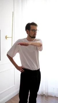 Young dark-haired man exercising at home in the early morning Foto stock