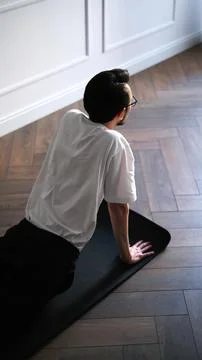 Young dark-haired man practicing yoga at home early in the morning on a mat Fotos de archivo