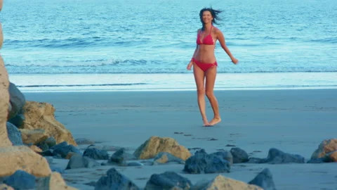 A young dark-haired woman is about to swim in the sea. Video stock 225154553