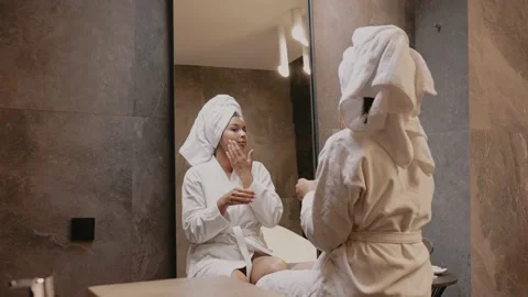 Young dark-skinned brunette in front of a mirror in a dressing gown. Skin care Stock-Footage 162500662