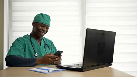 Young dark-skinned doctor is talking to someone on the phone in his office. Good Stock Footage 134147865