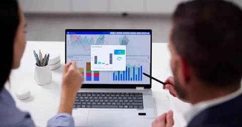 Young Data Analyst Analyzes KPI Dashboard On Computer In Office. Stock Photos