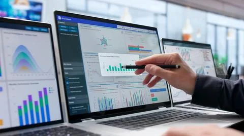 Young Data Analyst Studies Financial Dashboard On Laptop For Business Decisio Stock Photos