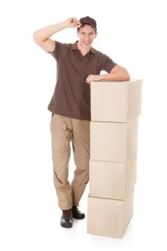 Young delivery man leaning on a stack of boxes over white background 스톡 사진