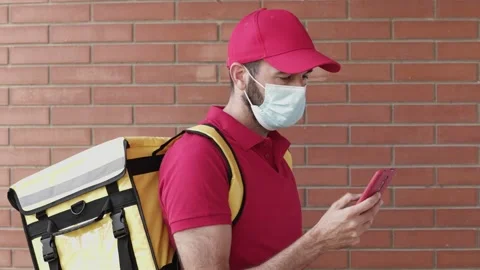 Young delivery man using mobile phone while delivering a package to a costumer Stock Footage 159450105