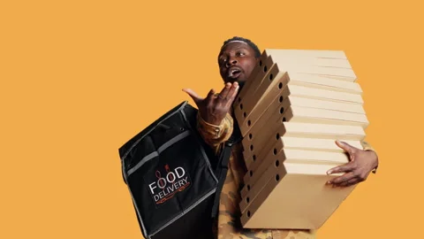 Young deliveryman giving huge stack of pizza boxes to client, Video stock 260765191