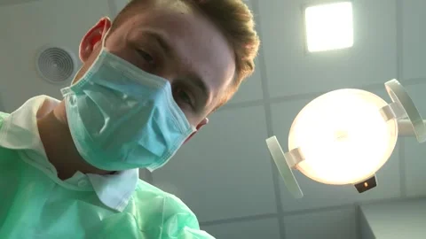 Young dentist adjusts the overhead light for optimal visibility Stock Footage 311987962