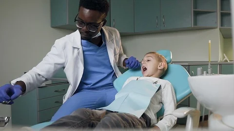 Young dentist checking the teeth of little boy. Stock Footage 104145394