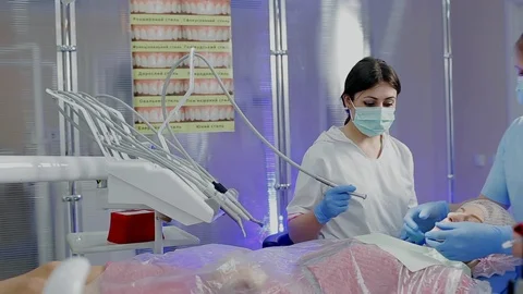Young dentist in protective mask fixing the patient's jaw Stock Footage 104348025