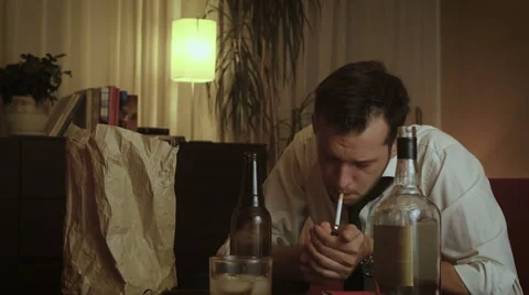 Young depressed man light cigarette, drinks and suggestively holds his breath 스톡 동영상 54702020