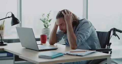Young depressed office worker sitting by desk worry about work. Disabled invalid Stock Footage 149181678