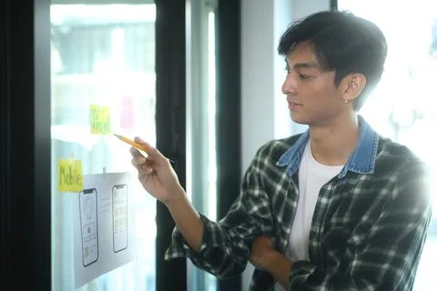 Young designer analyzing design elements and sketching to visualize ideas on a Stock Photos