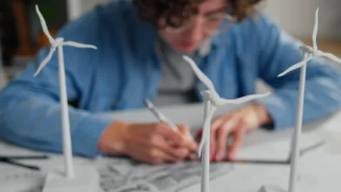 Young designer creating wind turbine models during a sustainable energy proj Stock Footage 323716186