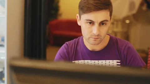 Young designer sitting at the table and working on a computer Stock Footage 29675212