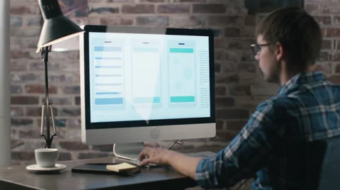 Young designer is working on a computer and developing an user interface Video stock 57230879