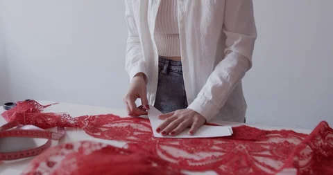 A young designer works in the workshop and cuts textiles with scissors Stock Footage 129858280
