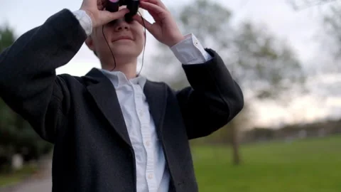 Young detective observing with binoculars in a park Stock Footage 316956828