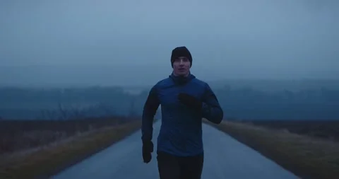 Young determined athlete running fast down long urban road, training hard Video stock 148331865