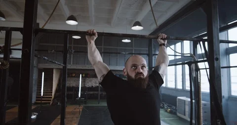 Young determined Caucasian athletic man doing pull-ups during functional workout Video stock 116806375