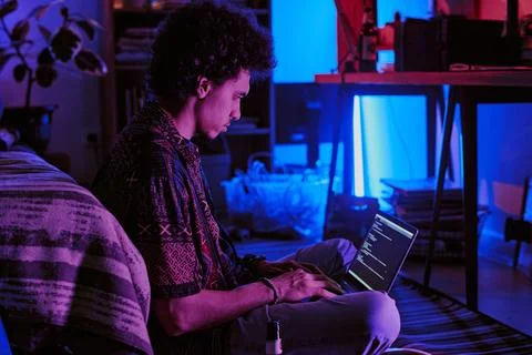Young Developer Coding in Neon Room Stockfoto's