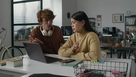 Young Developer Explaining New Idea to Brunette Girl Looking at Laptop Screen Stock Footage 299251783