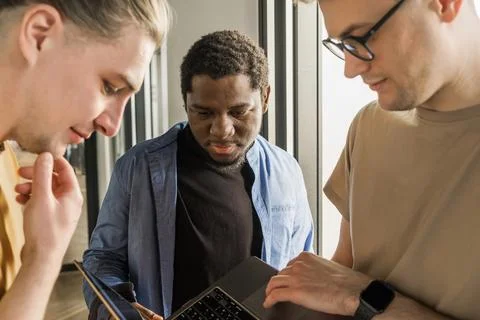 A young developer gives new project tasks to his partners. Business people are 库存照片