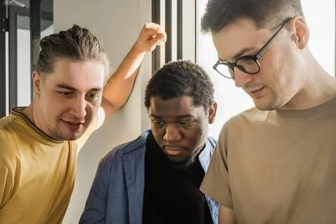 A young developer gives new project tasks to his partners. Business people are 库存照片