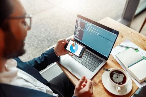Young developer programmer freelancer in glasses working on project in cafe Stock Photos