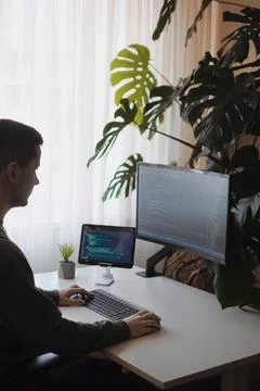 Young developer work with curved screen and tablet.Freelancer is working at home Stockfoto's