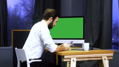 Young developer working at trendy start up office, checking his smartphone Stock Footage 70972788