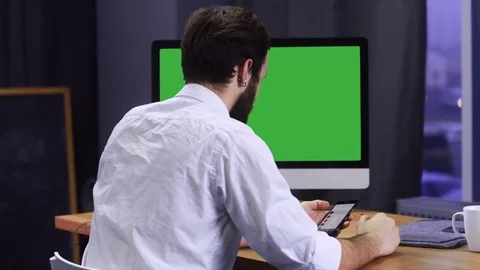 Young developer working at trendy start up office, checking his smartphone Stock Footage 70972961