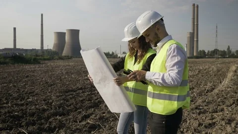 Young developers engineers using a blueprint and tablet pc working together o Stock Footage 82177714