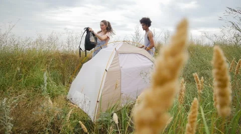 Young different racial couple resting in a tent on the beach Stock Footage 57106736