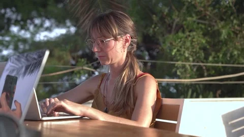 Young digital nomad woman doing remote work on laptop at outdoor terrace cafe Vidéo 345046583