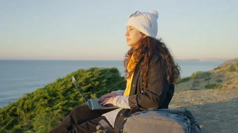 Young digital nomad working on laptop computer with view to ocean on sunny day Stock Footage 289678248