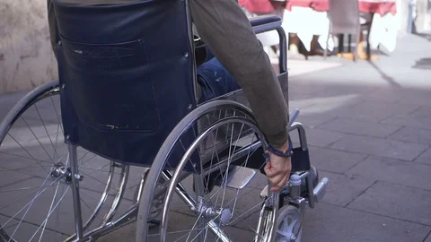 Young disable man pushing his wheelchair on the crowded sidewalk - slow motion Video stock 121194333