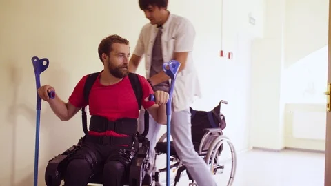 Young disable man in the robotic exoskeleton Stock Footage 94073187