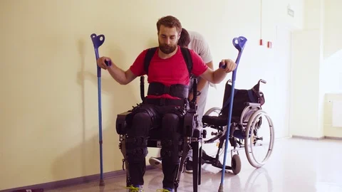 Young disable man in the robotic exoskeleton Video stock 94073591