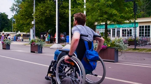 Young disable man walking in the park in wheelchair Stock Footage 93843475