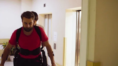 Young disable man walking in the robotic exoskeleton Stock Footage 94079973