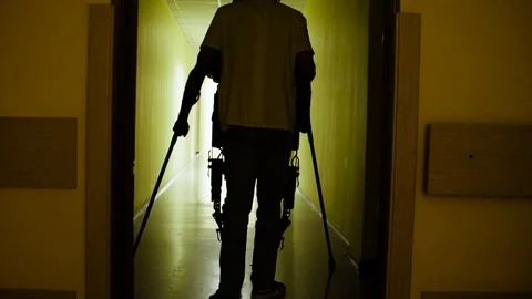 Young disable man walking in the robotic exoskeleton Stock Footage 94085959