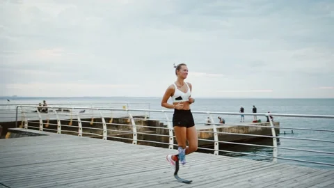 Young disabled female runner training at seaside, slow motion Stock Footage 137793537