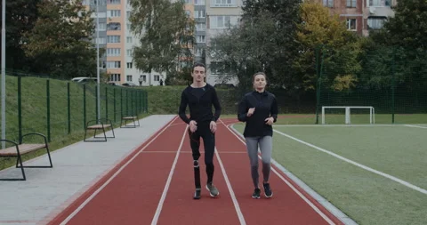 Young disabled man and pretty sports woman jogging. Male athlete with running Stock Footage 148484120