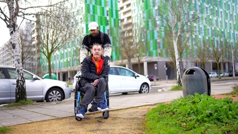 Young disabled man enjoying a stroll with his friend in the city Stock Footage 301686781