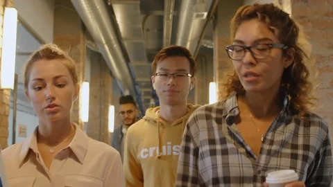 Young Diverse Colleagues Walking through Hallway and Speaking Vidéo 126132497