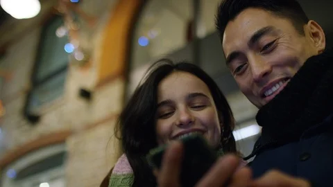 Young diverse couple using a phone together out in the city Stock Footage 100322097