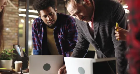 Young diverse creative team discussing plan details with experienced leader Stock Footage 156300287